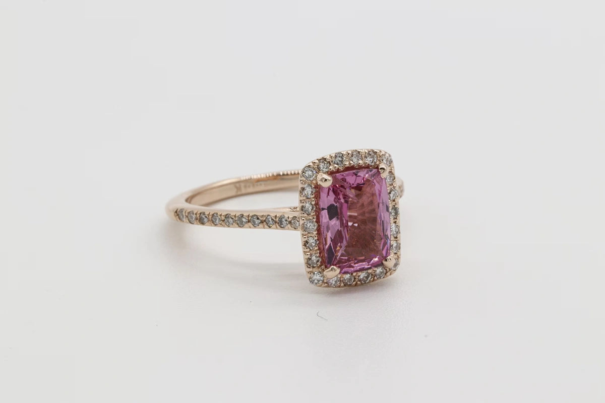 Gold and pink stone ring on a white surface