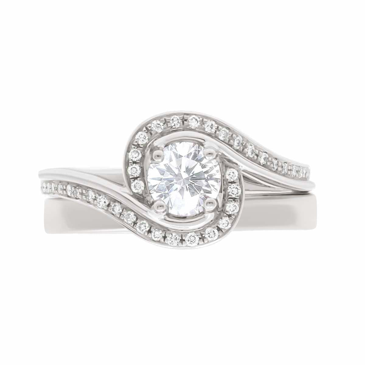Contemporary Style Engagement Ring in white gold, with a plain wedding ring, lying flat, with a white background