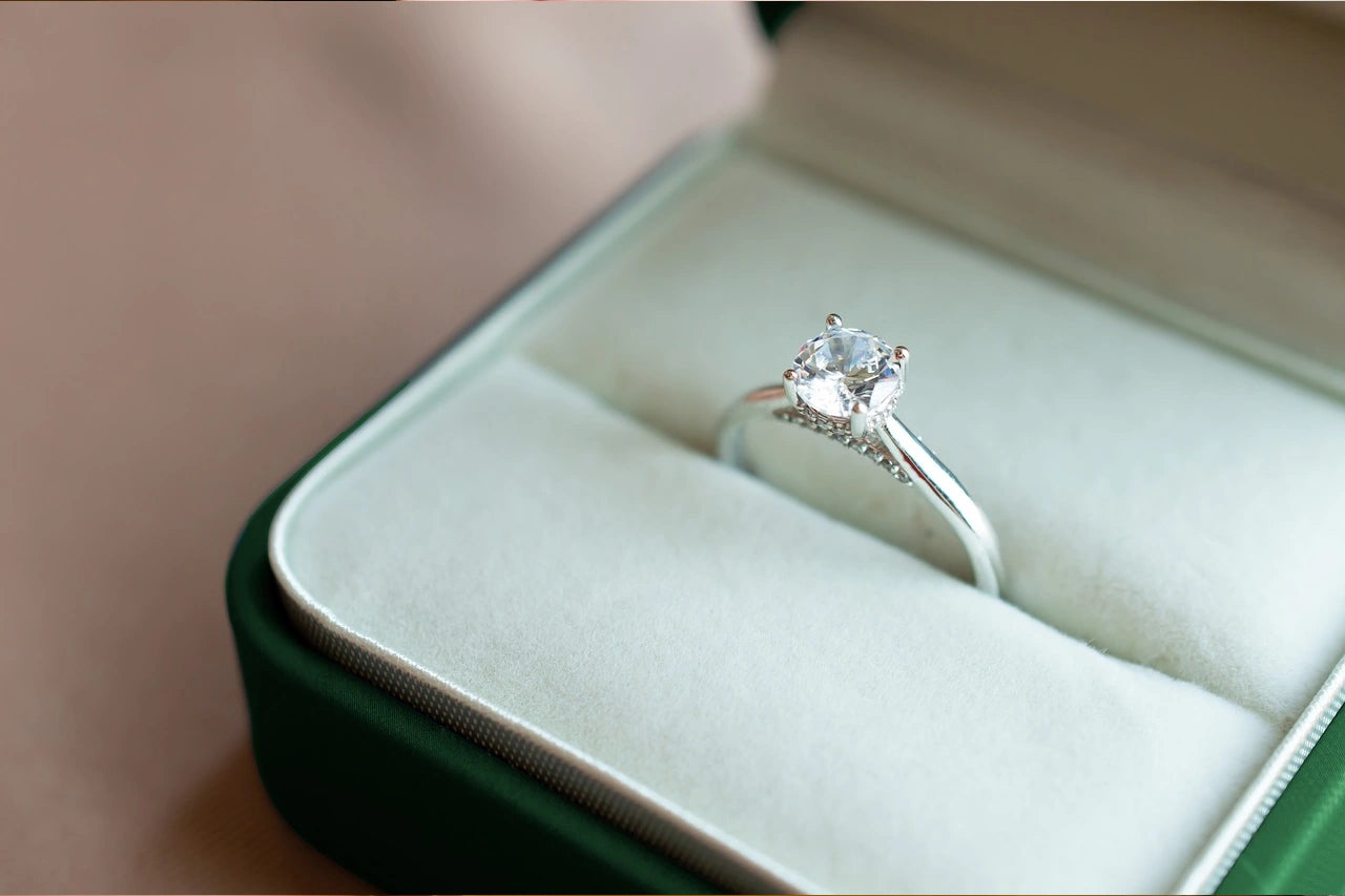 A diamond engagement ring placed inside the opened box