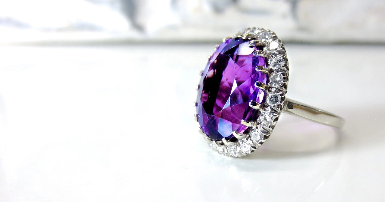 A beautiful purple stoned engagement ring placed with white background 