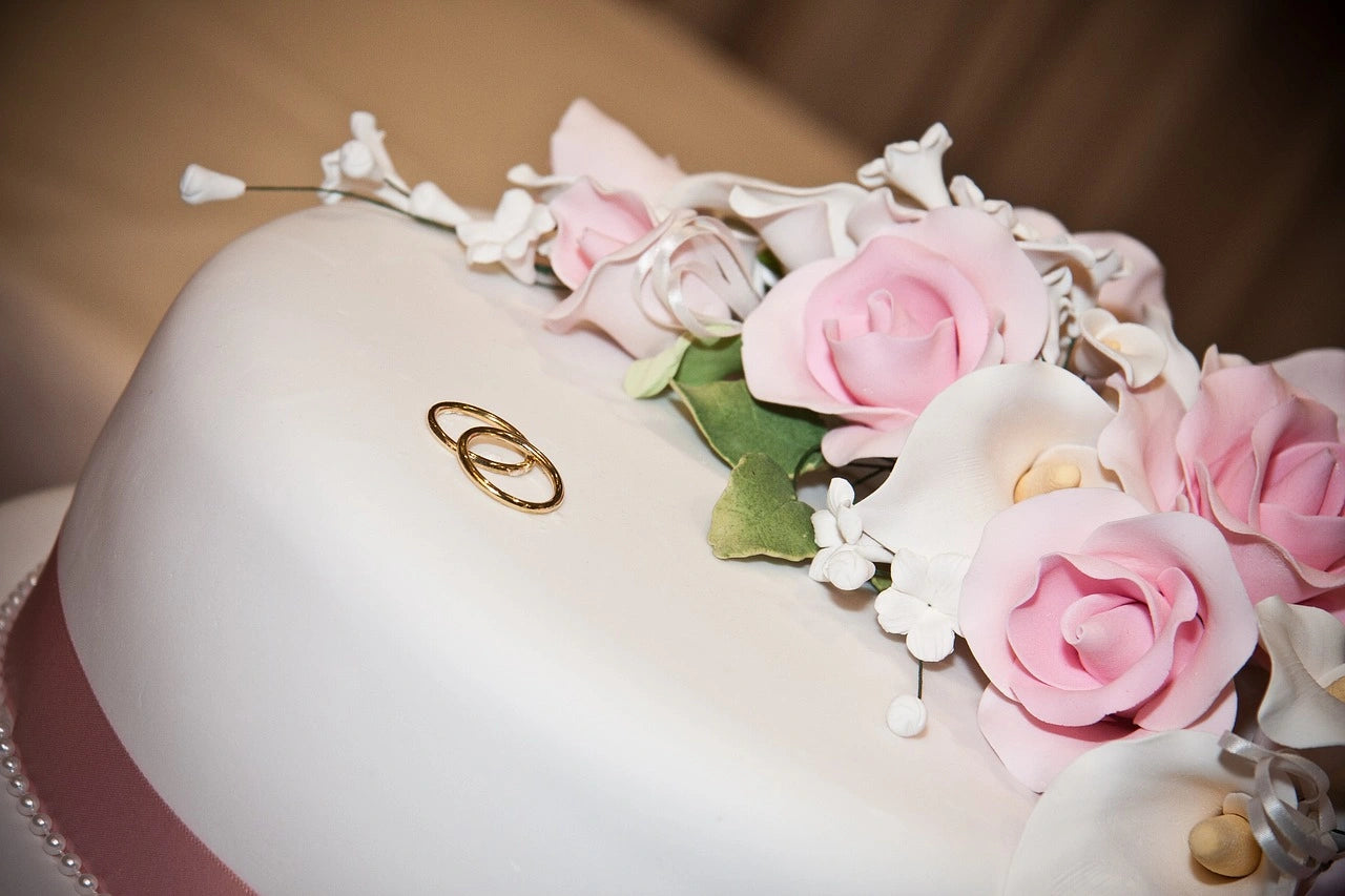 Two beautiful engagement rings placed on a well decorative cake
