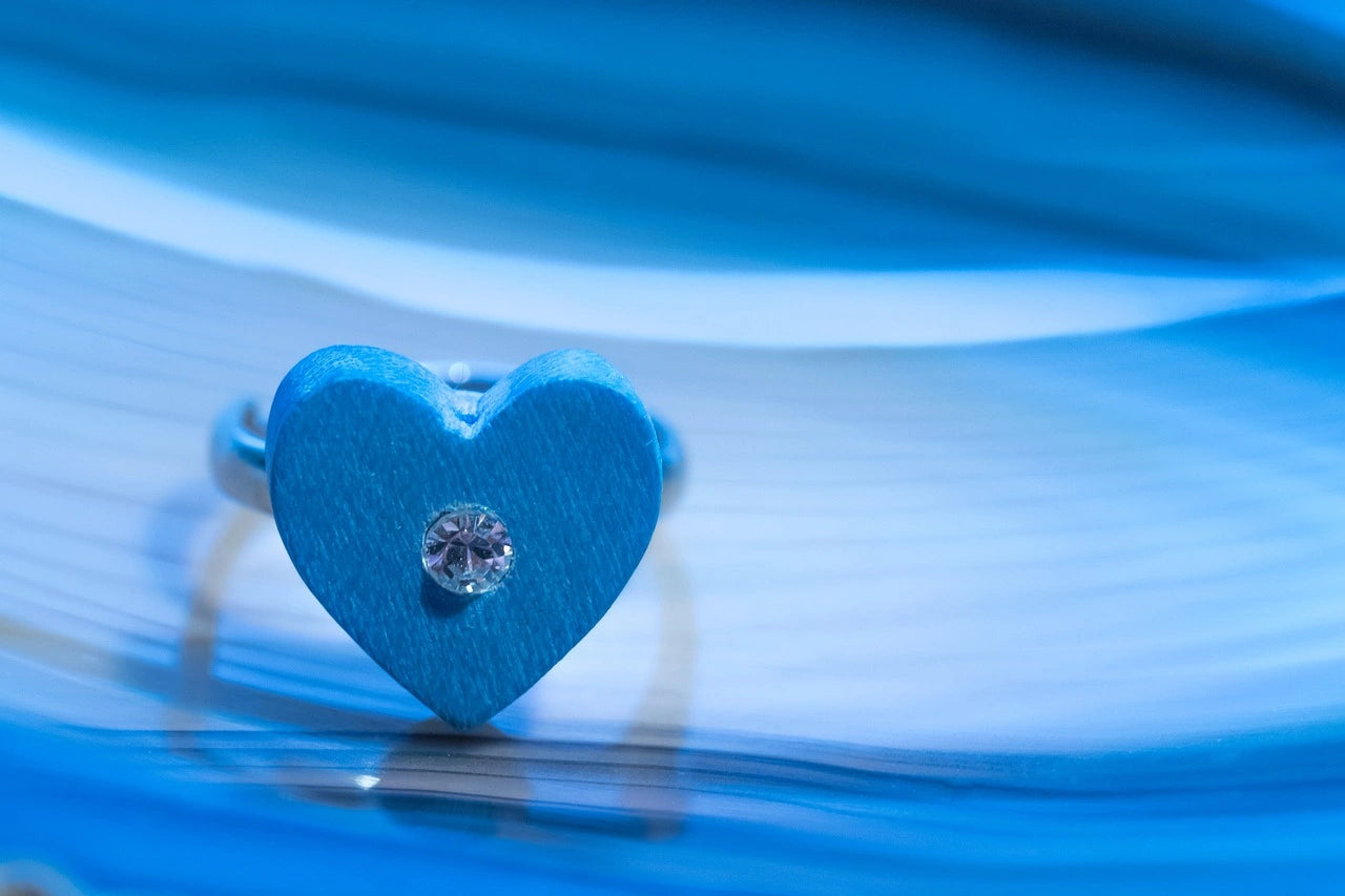 An beautiful heart shaped engagement ring placed in a blueish white background
