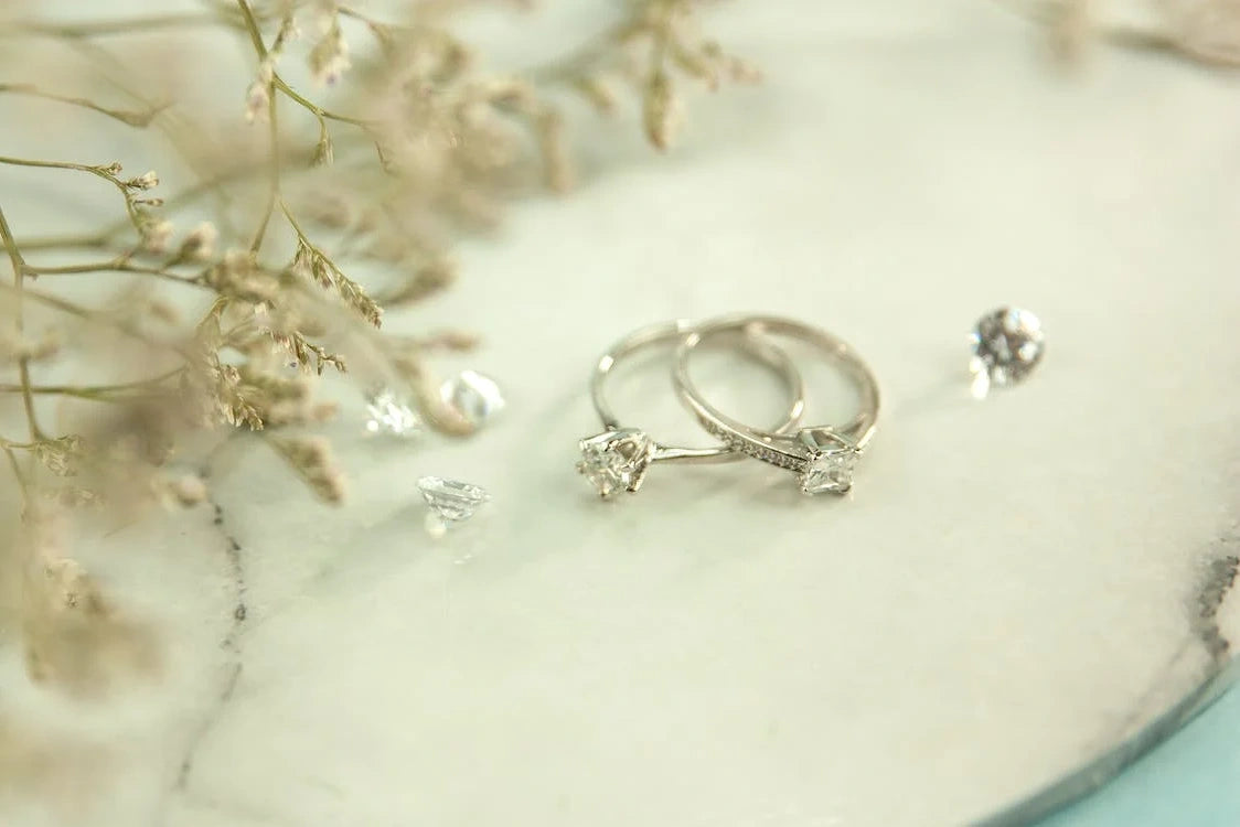 Engagement rings placed on twigs of the white plants