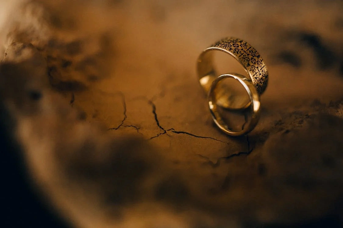 Two goldish engagement rings placed on a soil