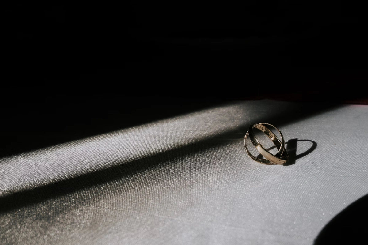 silver-colored ring placed on the leaf in a dark background
