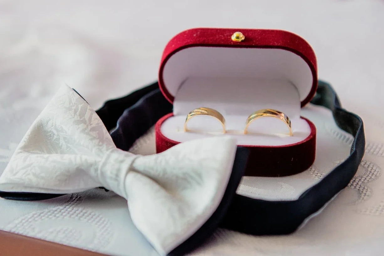 Wedding bands in a jewelry box near a Bow tie
