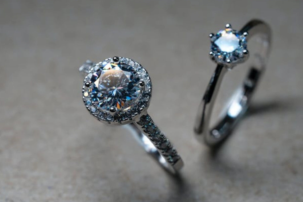Two diamond engagement rings on a surface