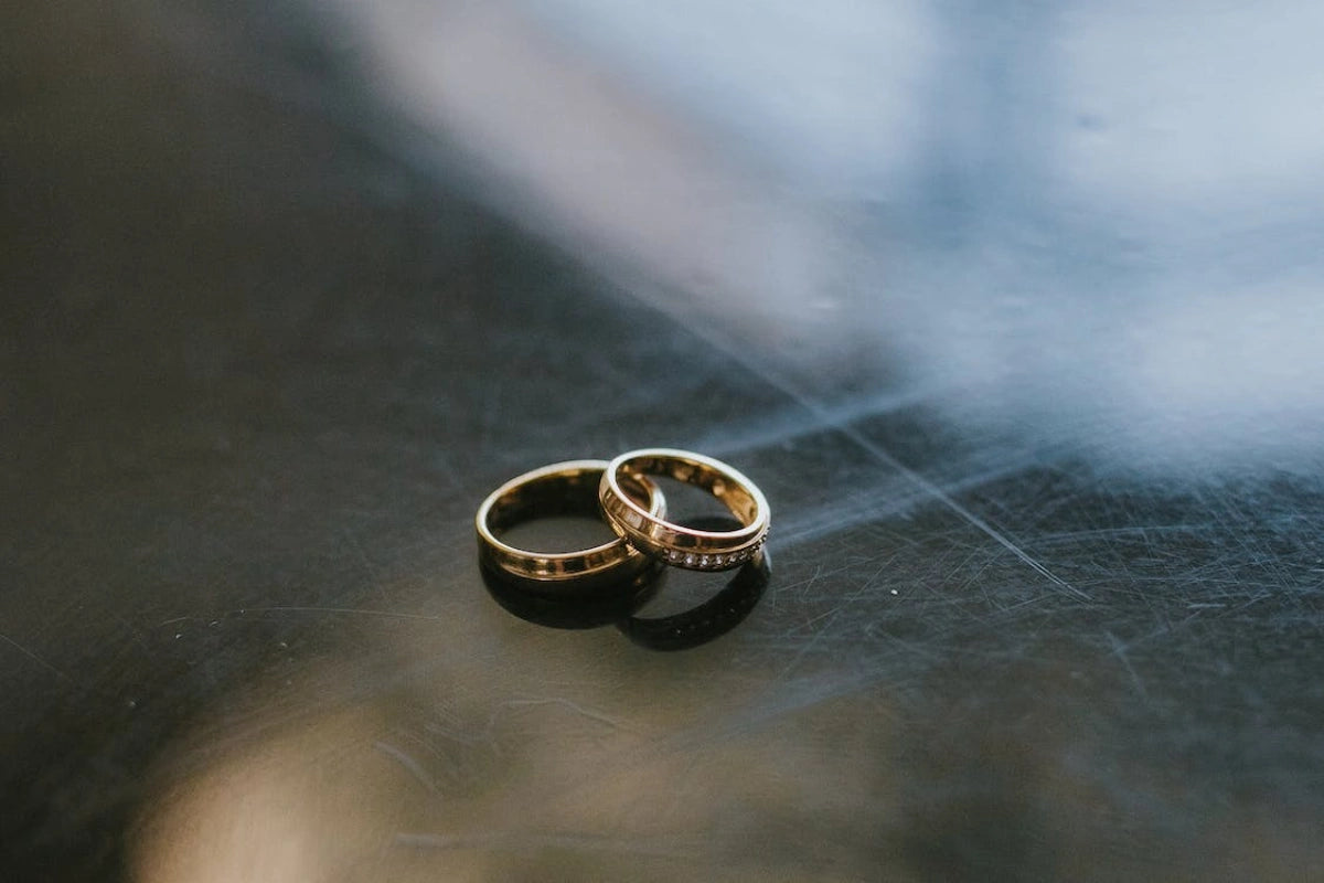 Gold engagement rings on a black surface