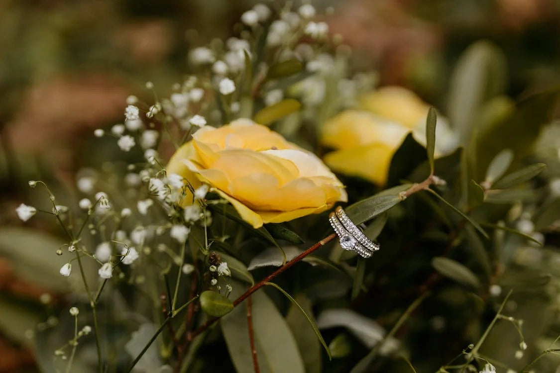 Engagement ring is hung on a beautiful yellow color rose stem