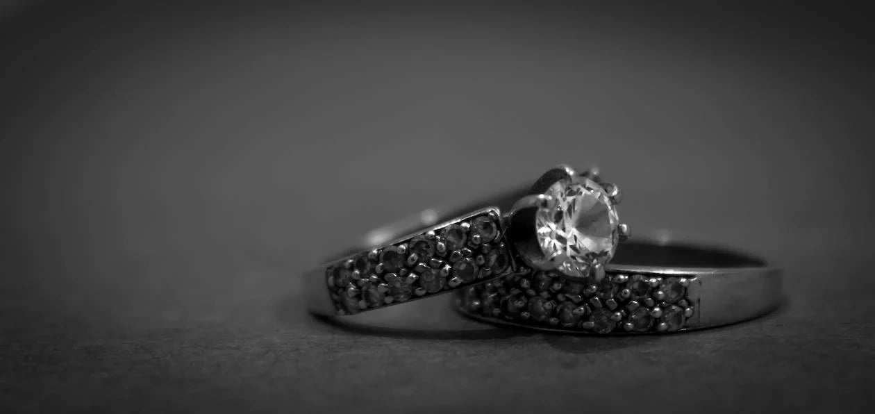 Two beautiful white stoned engagement rings placed with a dark background