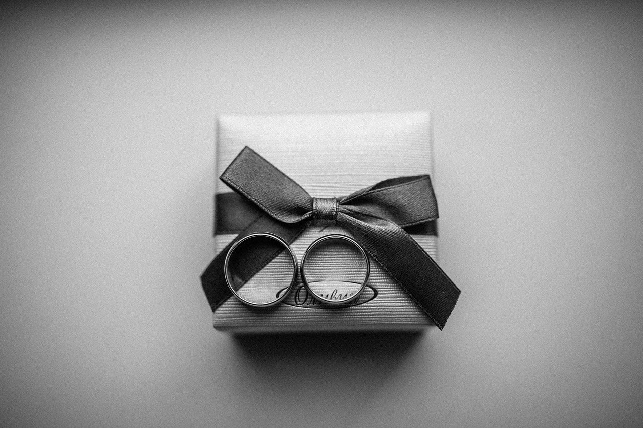 Two engagement rings placed on a engagement ring box with a black and white background