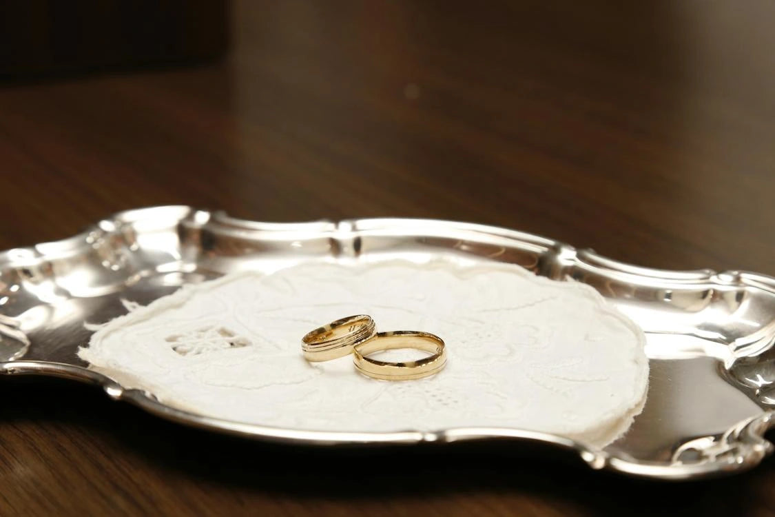 Two gold engagement rings placed inside the steel plate