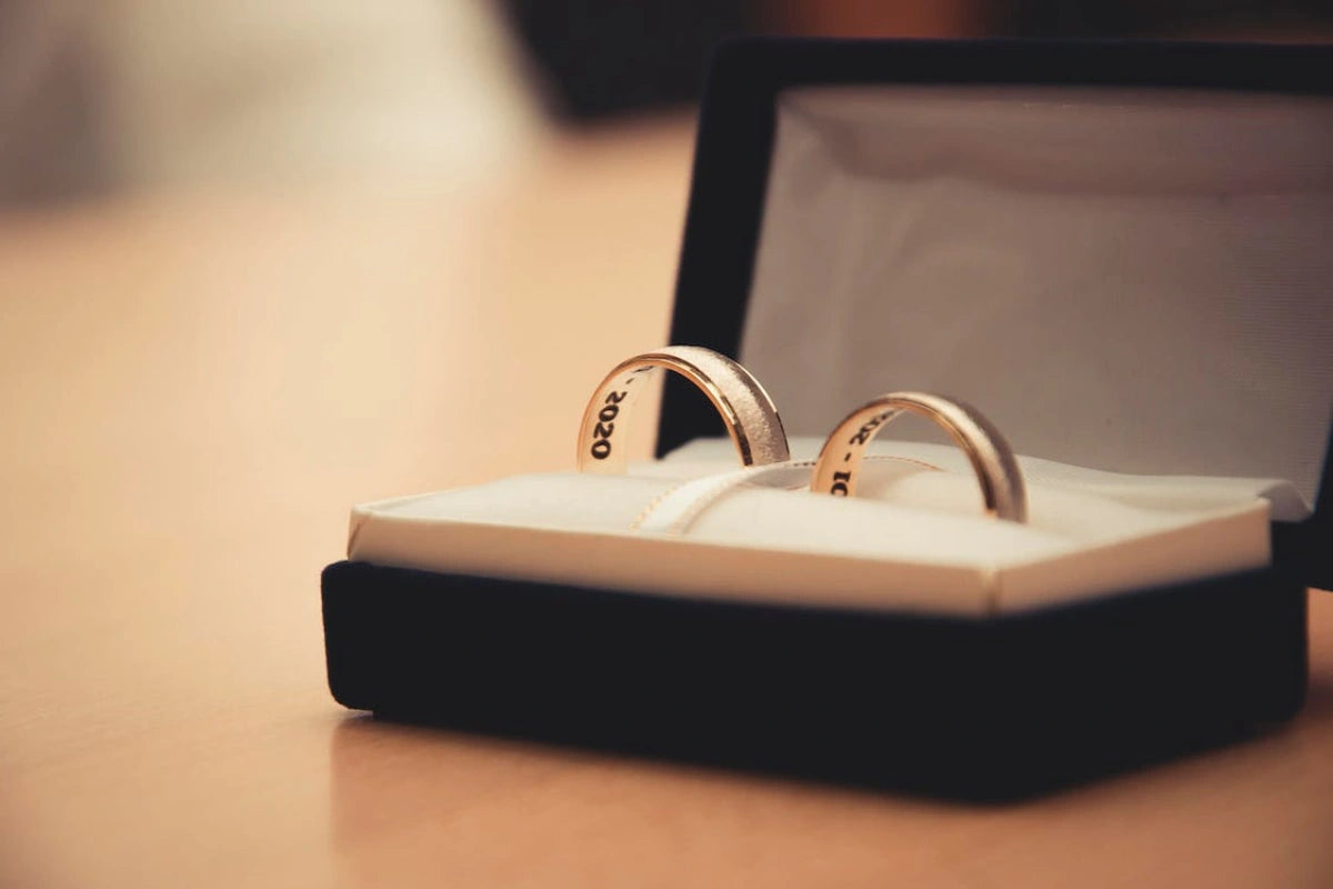two gold rings inside the opened jewelry box