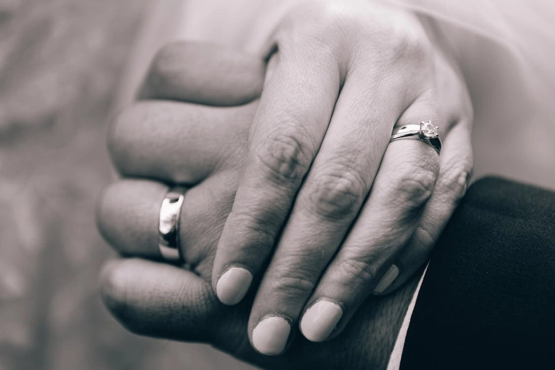 In a monochromatic embrace, the couple's hand unit 