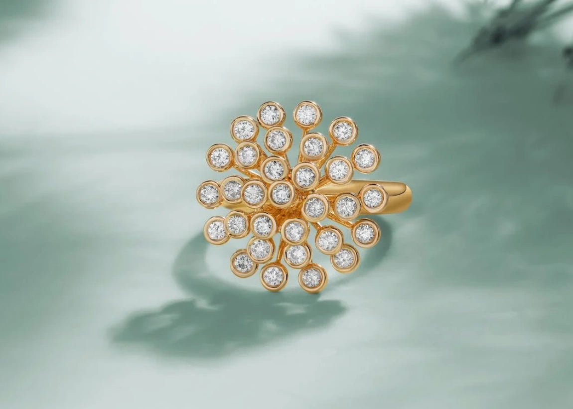 A beautiful well structured gold ring with diamond placed on a white with shadow surface