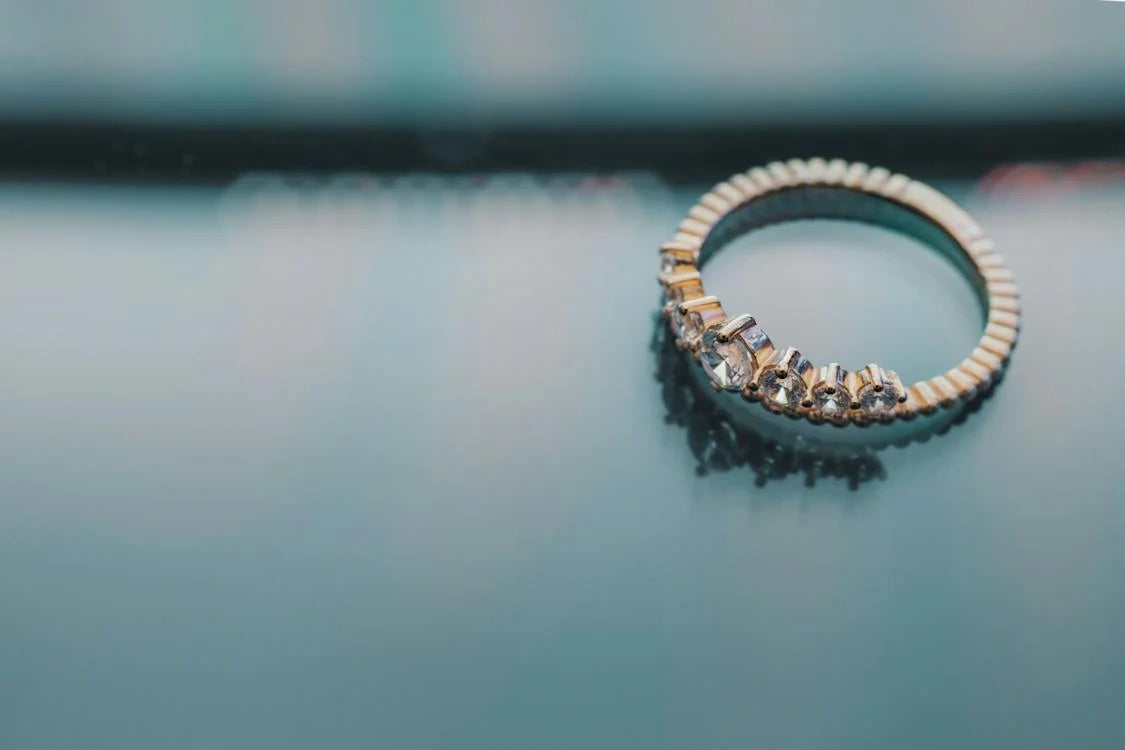A stunning engagement ring placed on a glass surface