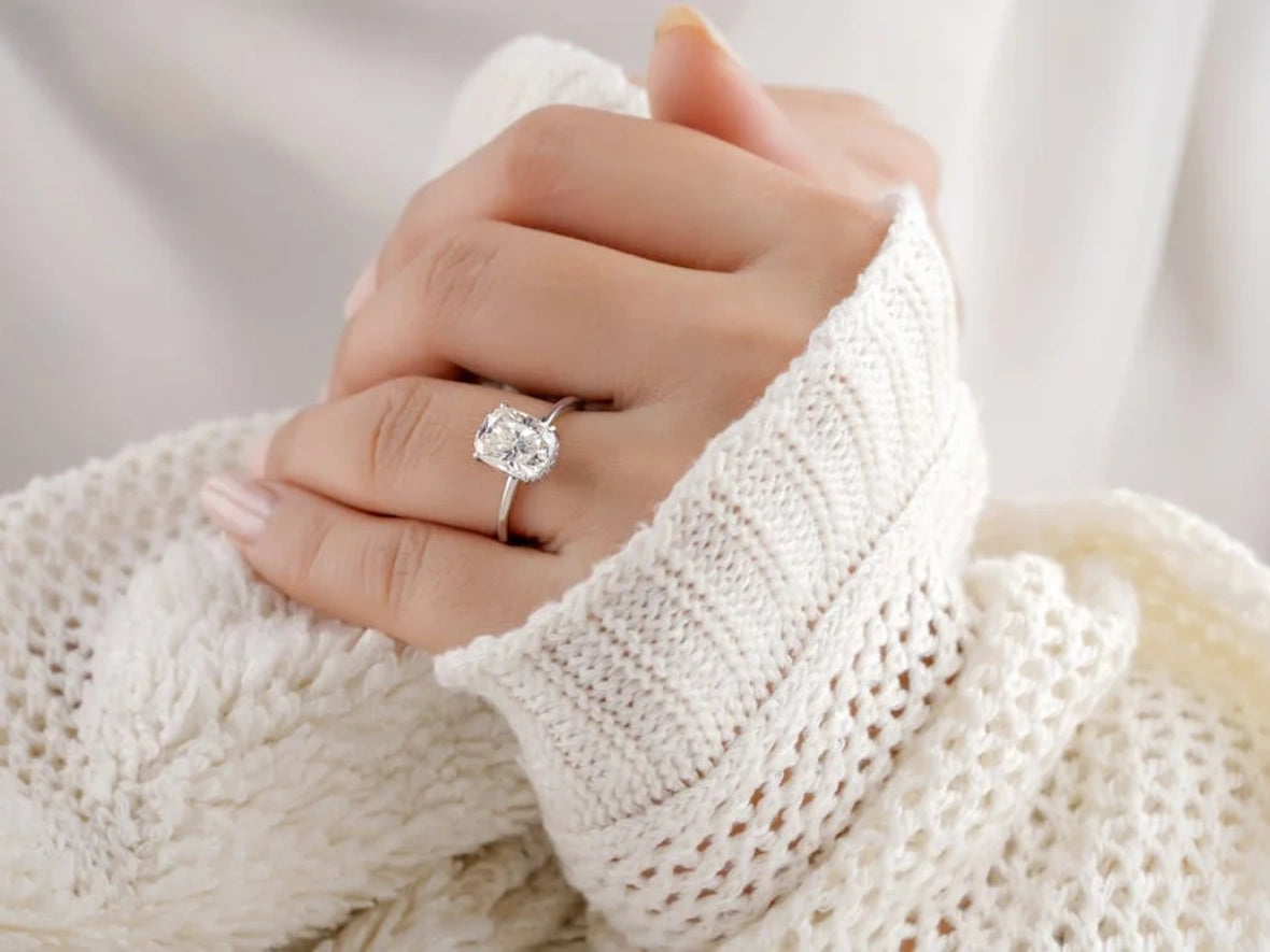 A person in white wearing an engagement ring