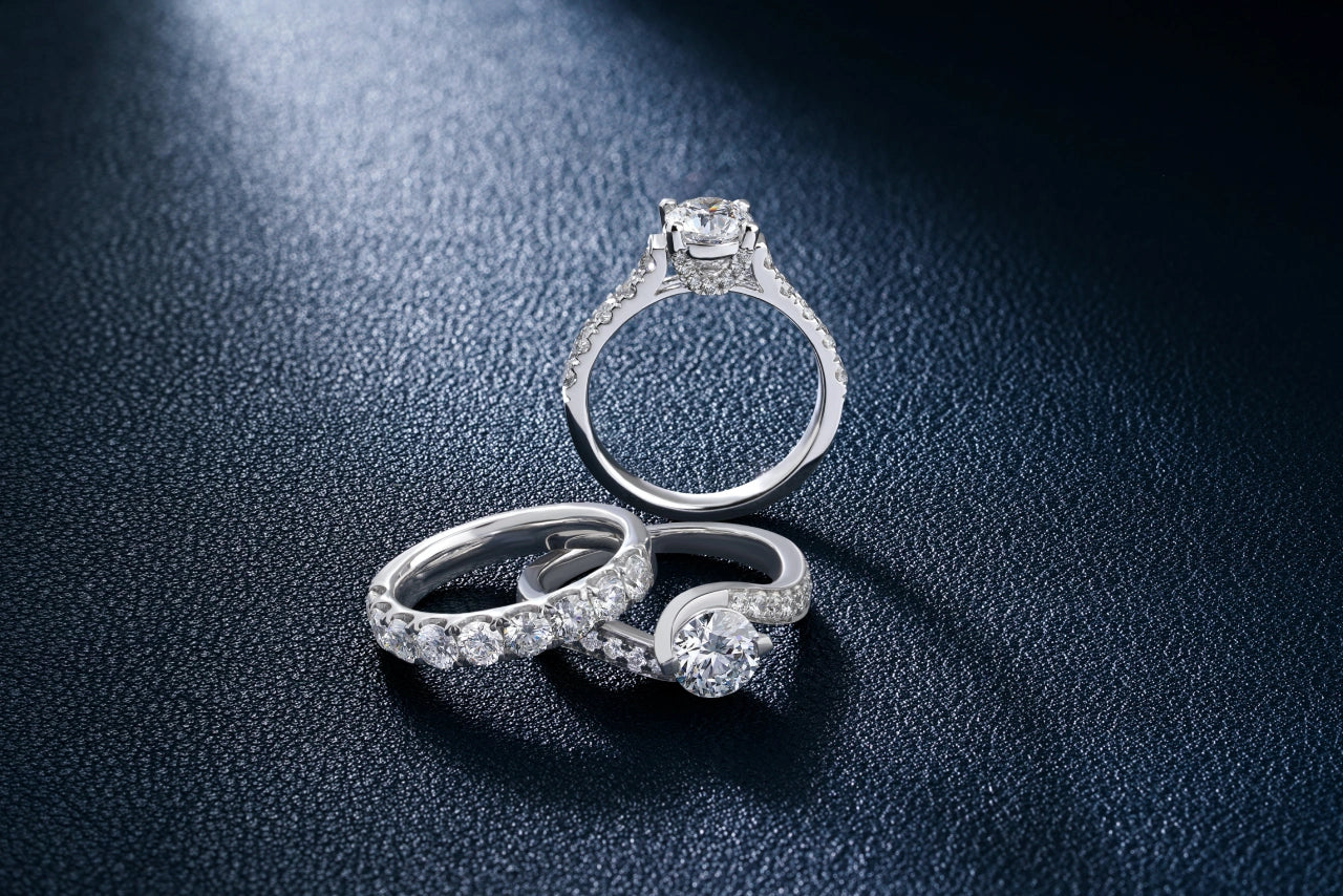 Three engagement rings placed in a illuminated dark room