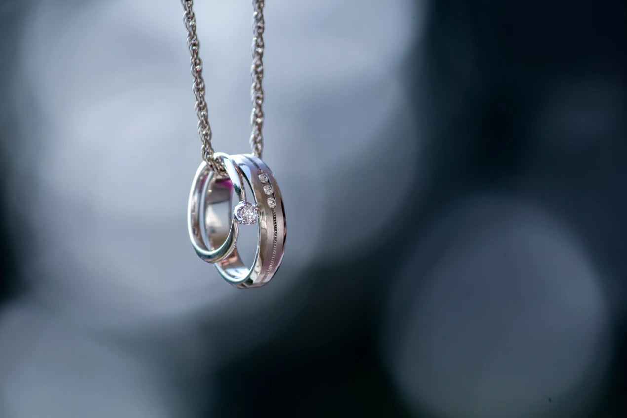 Silver colored ring hanging on the chain
