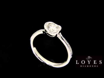 Unusual Halo Engagement Ring in white gold with a matching diamond wedding band revolving in front of a black background