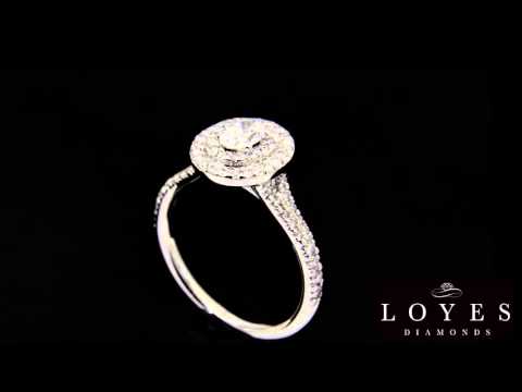 Double Halo Oval Engagement Ring In white gold rotating in front of a black background